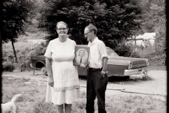 Couple-Holding-a-Portrait-of-Their-Son-Standing-in-Front-of-the-Car-He-Drowned-in-Clay-County-1977-TW